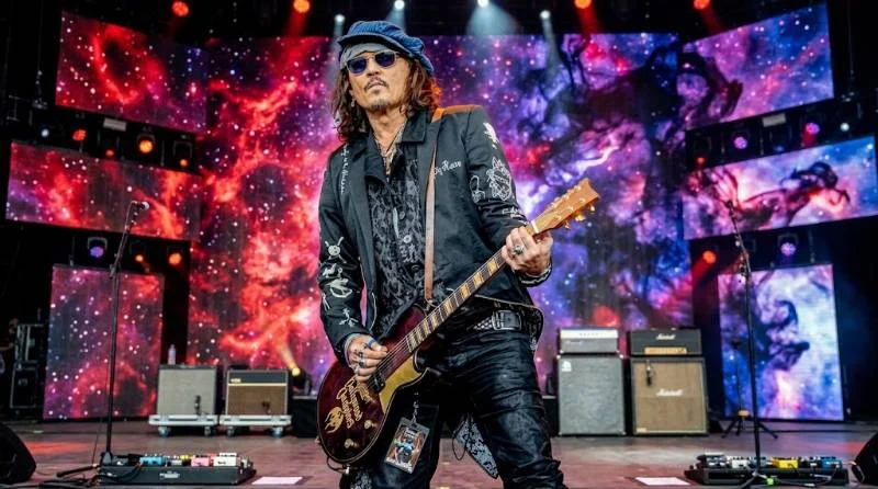 Johnny Depp playing electric guitar onstage with his band